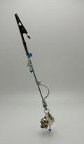 A gothic-style silver-toned car roach clip wand with blue beads, a skull charm, shown on a neutral gray background.